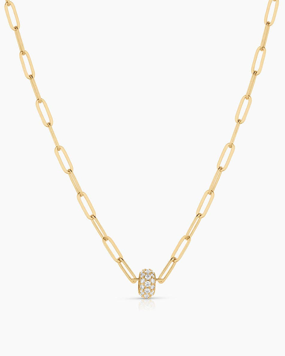 Gold necklace with a small round pendant on a white background