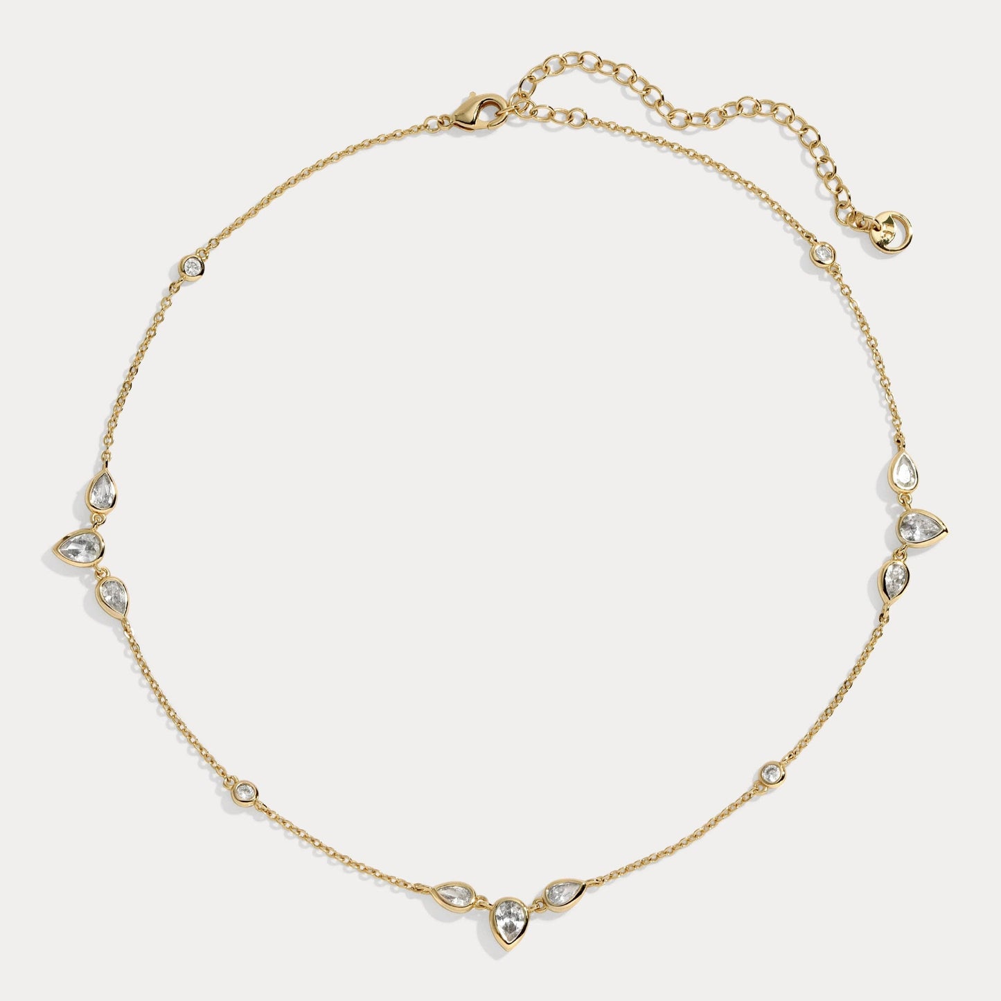 The Aurora Choker by Lili Claspe features teardrop and round White Cz stones on a 14kt gold-plated chain with an extender for the perfect fit.