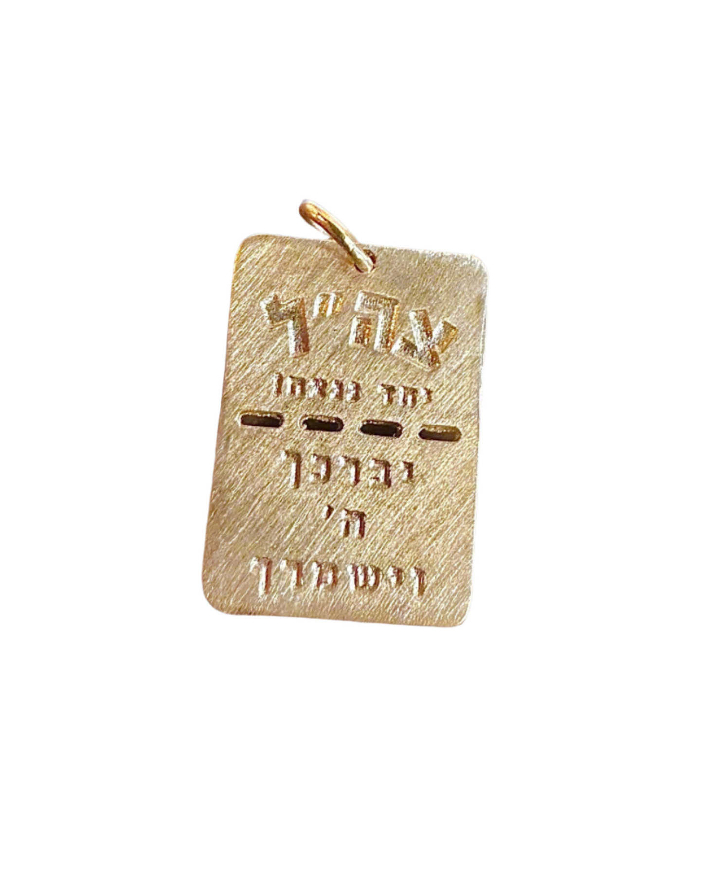 The BTH BRING THEM HOME Gold Dog Tag by Dylan James Jewelry/flower, featuring intricate Hebrew letters and delicate engravings, elegantly hangs against a blurred cobblestone street backdrop.