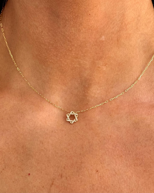 The ALIZA Gold Diamond Necklace by Dylan James Jewelry/flower features a delicate Star of David pendant, resting elegantly on the wearer’s neck.