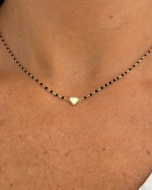 Necklace with a heart-shaped pendant on a person's neck