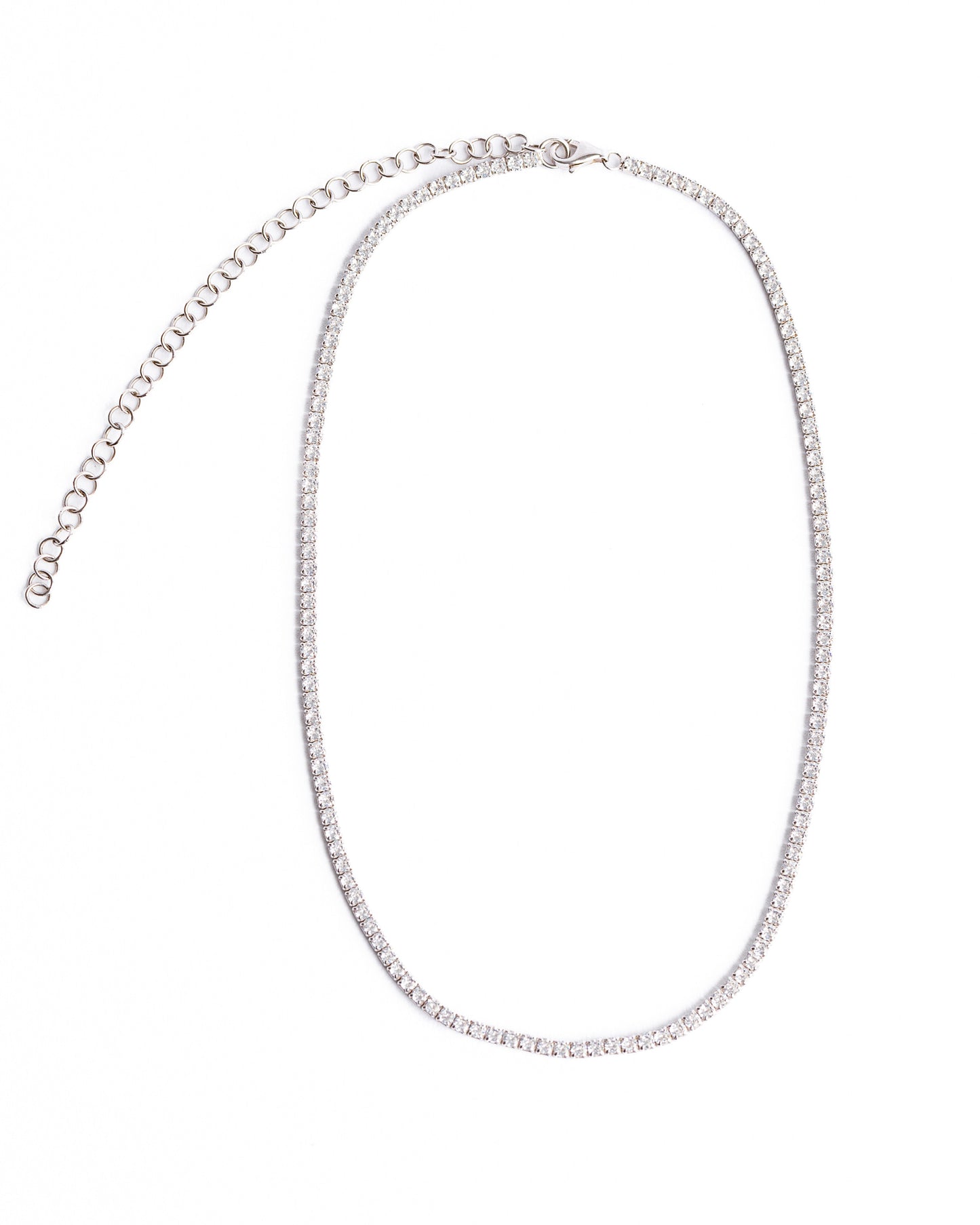 The KAYLA Tennis Necklace from Dylan James Jewelry, crafted with shimmering cubic zirconia and an adjustable clasp, is elegantly arranged in an oval shape on a plain white background.