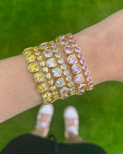 Three colorful bracelets on a wrist against a green grass background