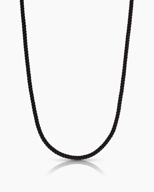 Black cord necklace on a white background
