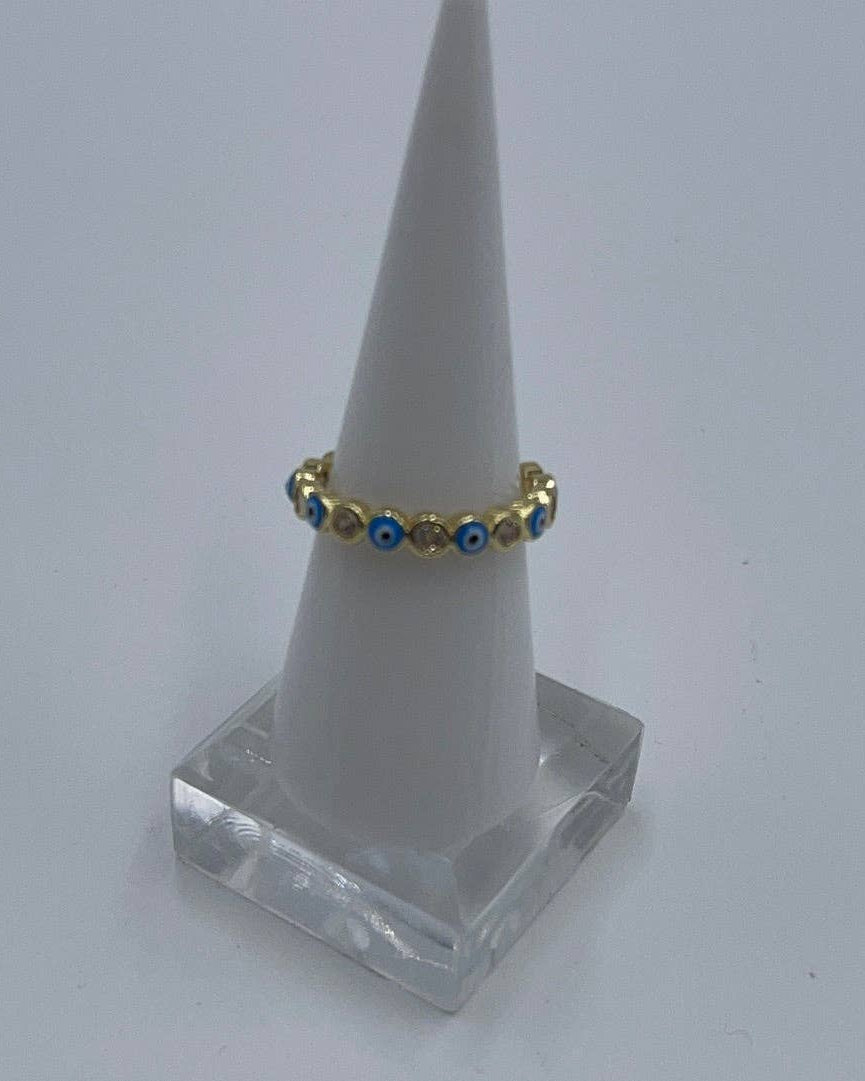 Gold ring with blue stones on a white cone stand against a white background