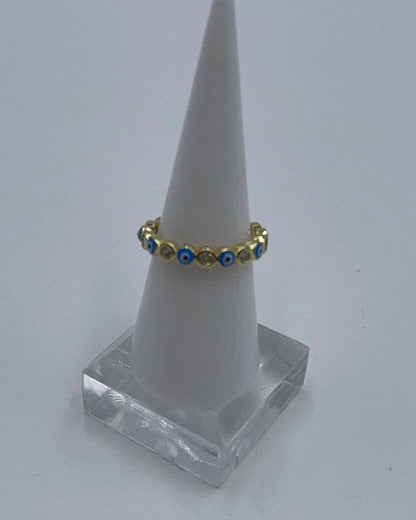 Gold ring with blue stones on a white cone stand against a white background
