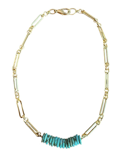 Gold necklace with turquoise beads on a white background