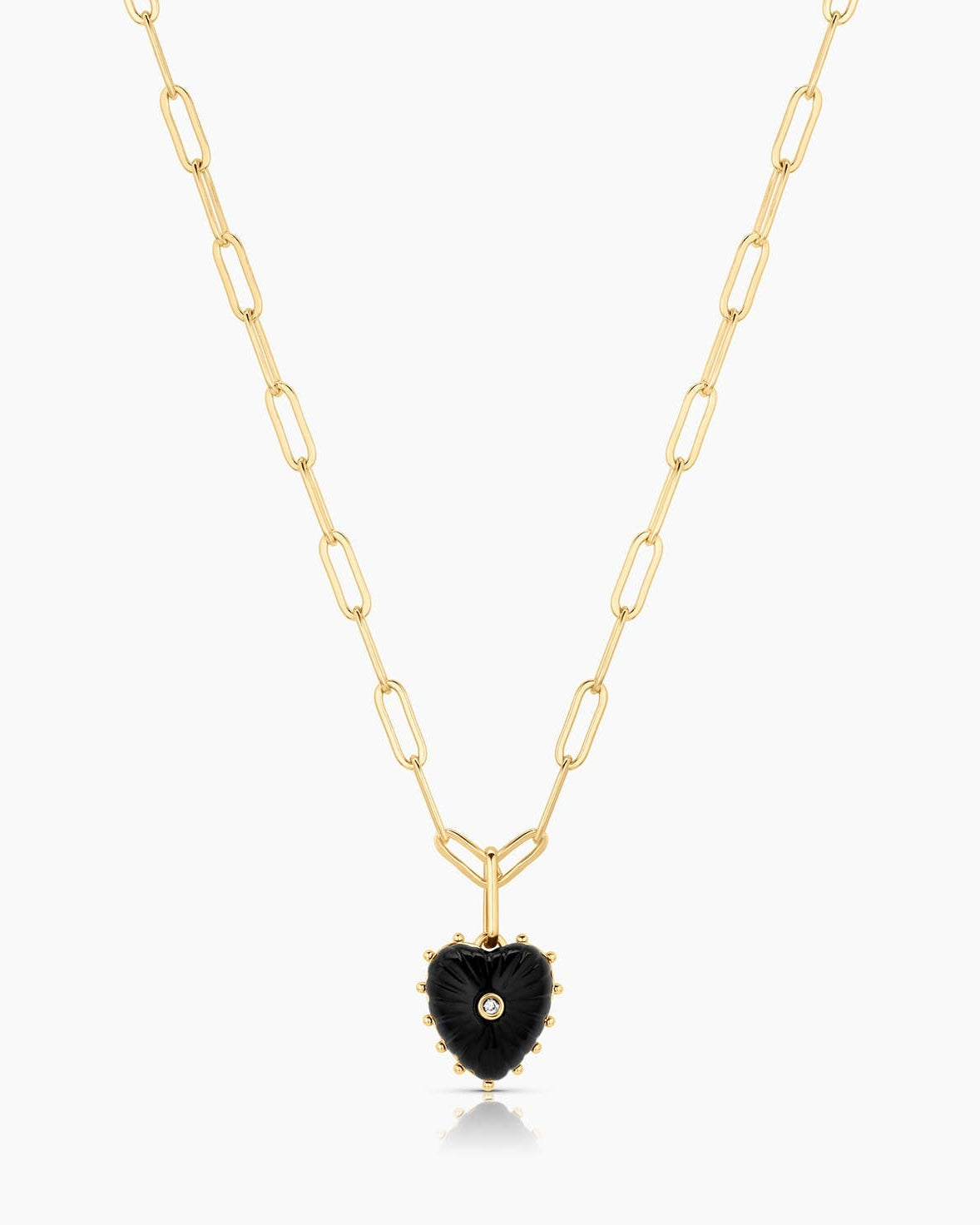 Gold necklace with a black heart-shaped pendant on a white background
