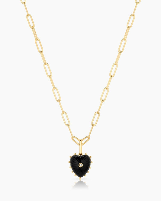 Gold necklace with a black heart-shaped pendant on a white background