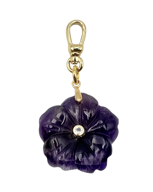 Purple flower-shaped keychain with gold accents on a white background