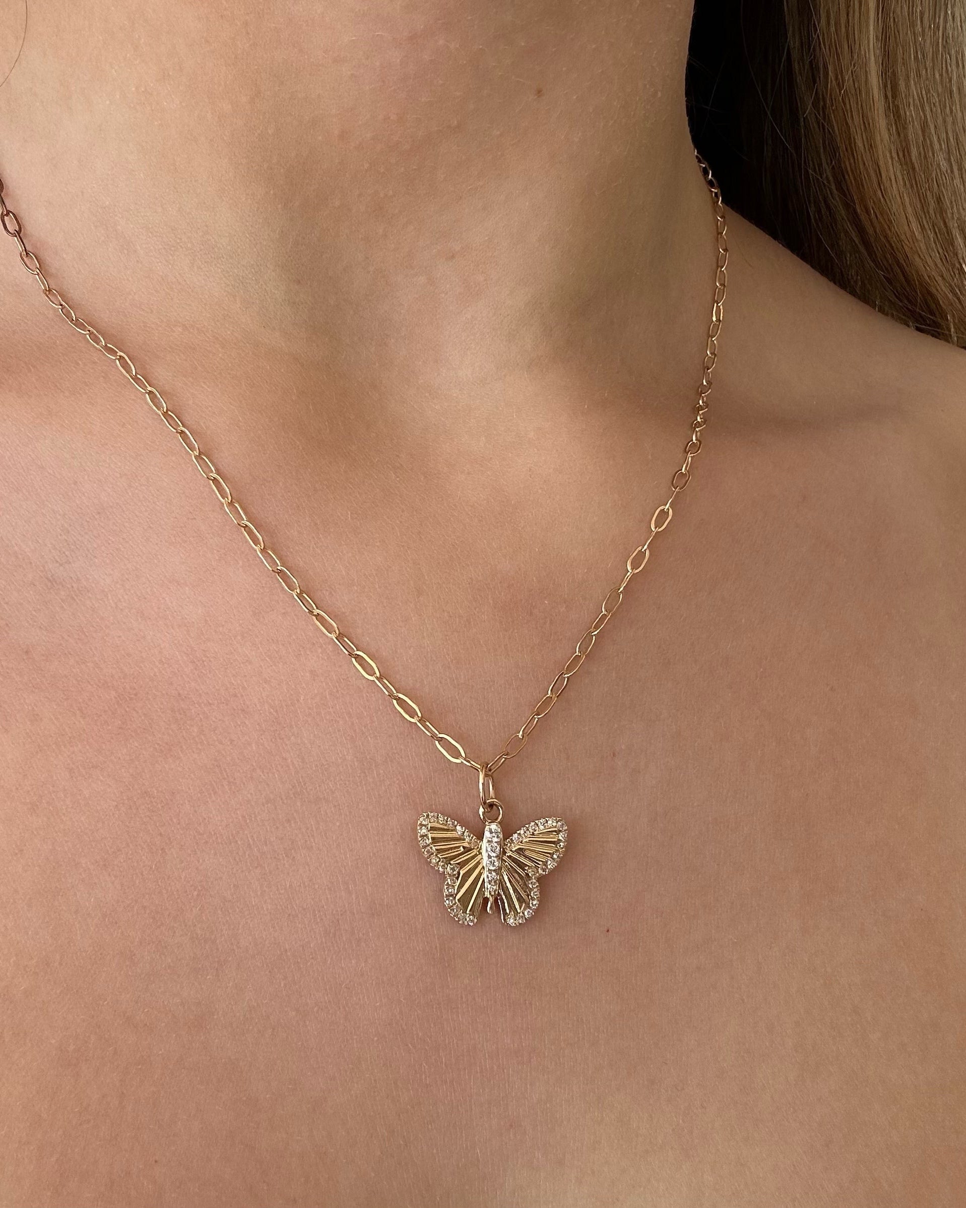 Gold butterfly necklace on a person's neck