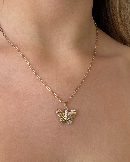 Gold butterfly necklace on a person's neck