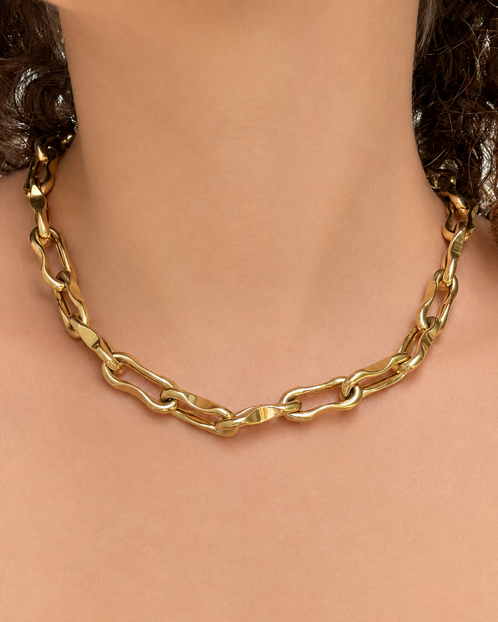 Gold chain necklace on a mannequin with a neutral background