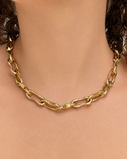 Gold chain necklace on a mannequin with a neutral background