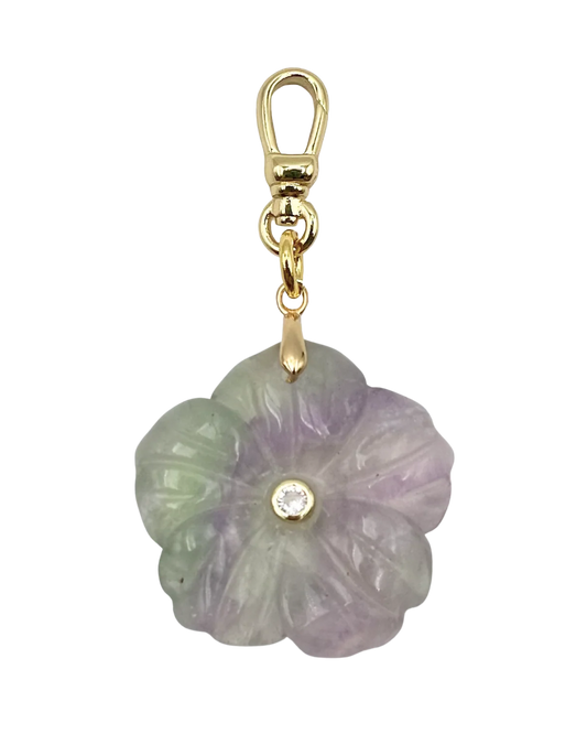 Flower-shaped jade pendant with gold clasp on a white background