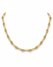 A gold paperclip chain necklace displayed in a curved U-shape against a solid white background.