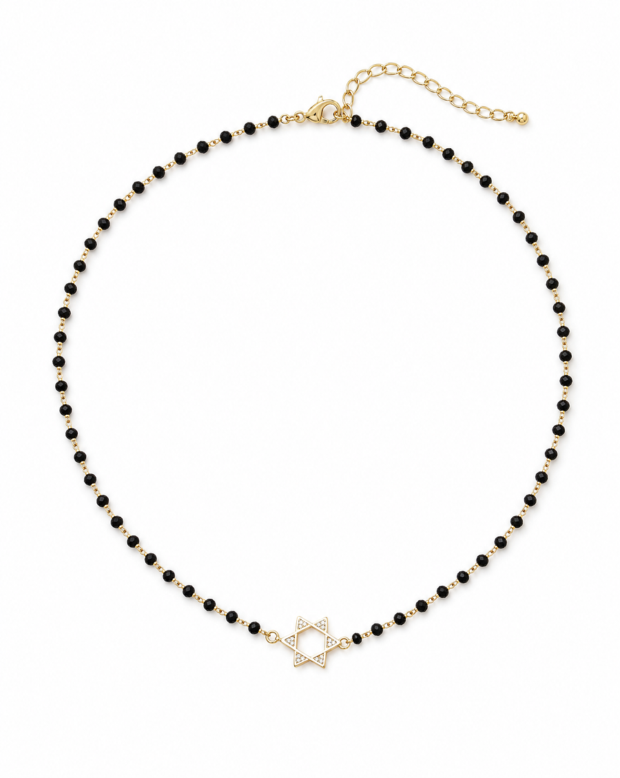 A delicate necklace featuring a strand of small black beads with a gold-tone Star of David pendant and matching gold-tone chain extender, shown on a plain white background.