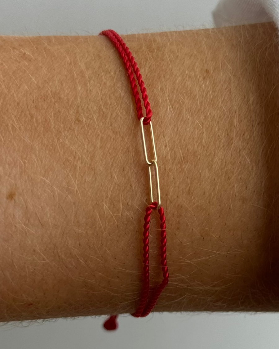 The hortense HORTENSE YOUNME Bracelet is a red adjustable cord bracelet with a small 14kt yellow gold chain link, offering a modern touch to your wrist.