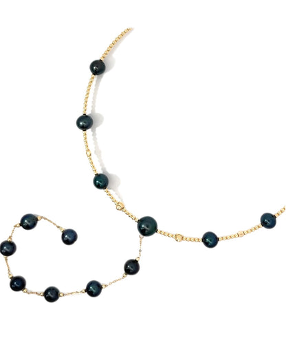 Necklace with black PEARLS on a YELLOW gold BEADED bendy comfortable wire against a white background