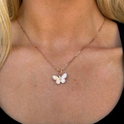 The SPENCER Butterfly Necklace by dylanjames, featuring a delicate 16" rose gold chain with a butterfly pendant, is worn around a person's neck.