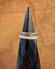 Three rings stacked on a black bottle against a brown background