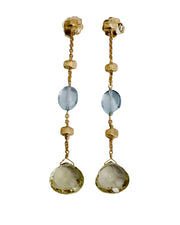 Pair of gold earrings with gemstones on a light gray background