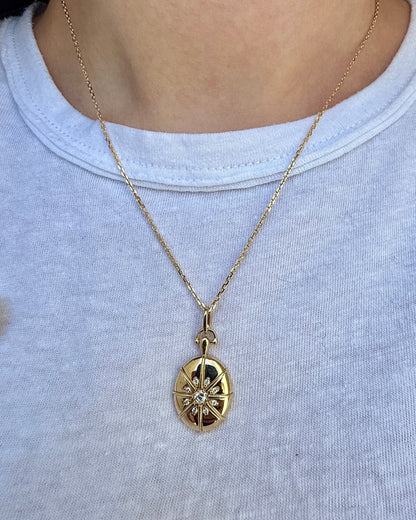 Gold necklace with a pendant worn by a person on a plain background
