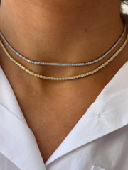 Two Dylan James Jewelry KAYLA Tennis Necklaces—one gold-plated silver, one silver—both with round cubic zirconia stones, are styled layered above the collar of a white shirt.