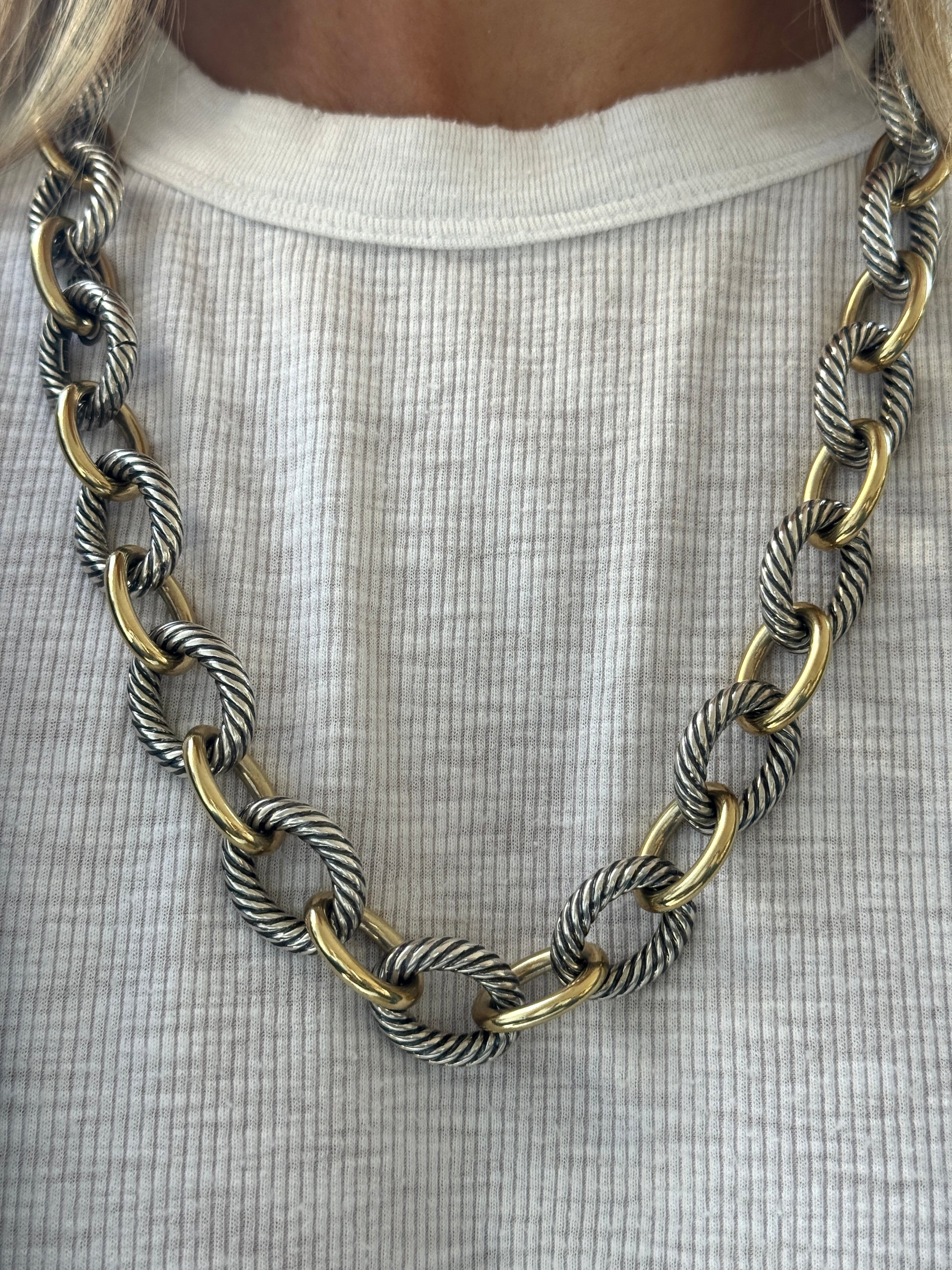 Necklace with gold and silver chain on a white shirt