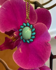 Necklace with a turquoise pendant on a pink orchid flower