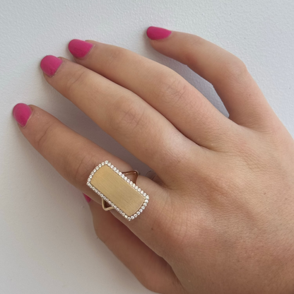 A hand with pink nail polish showcases a size 7 ring on the ring finger, the TWILA Diamond Ring by Dylan James Jewelry, featuring a captivating yellow gold center and radiant diamond border.