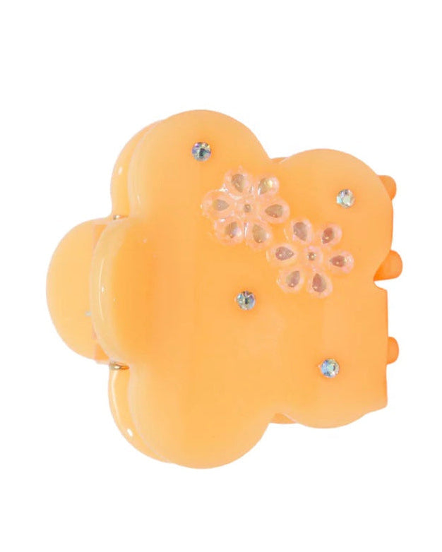 Yellow hair clip with floral design and rhinestones on a white background