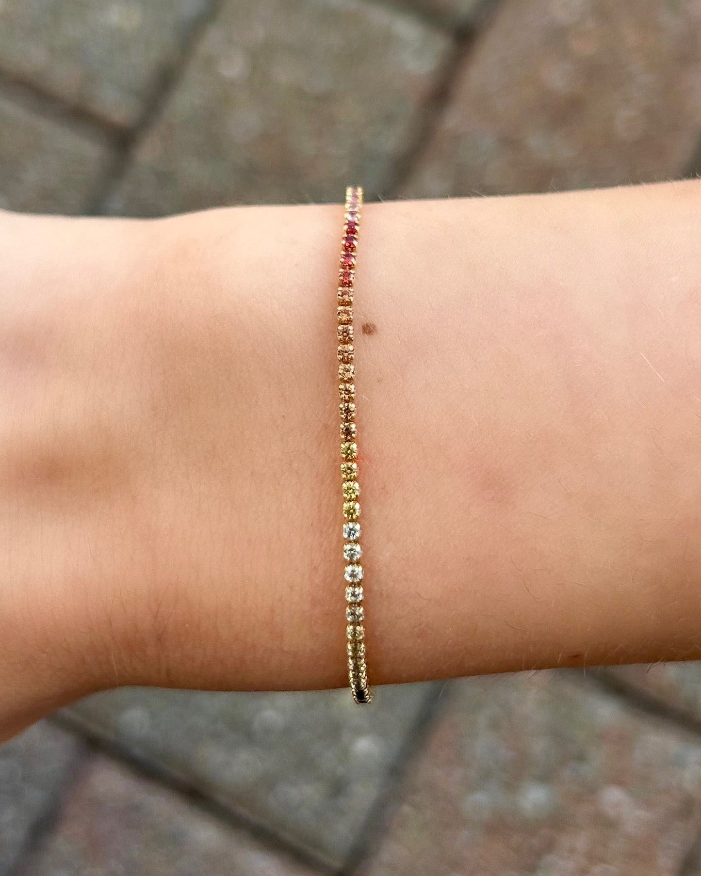 Bracelet on a wrist with a blurred pavement background