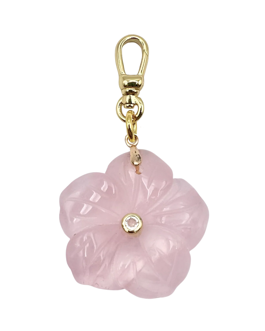 Pink flower-shaped charm with gold accents on a white background