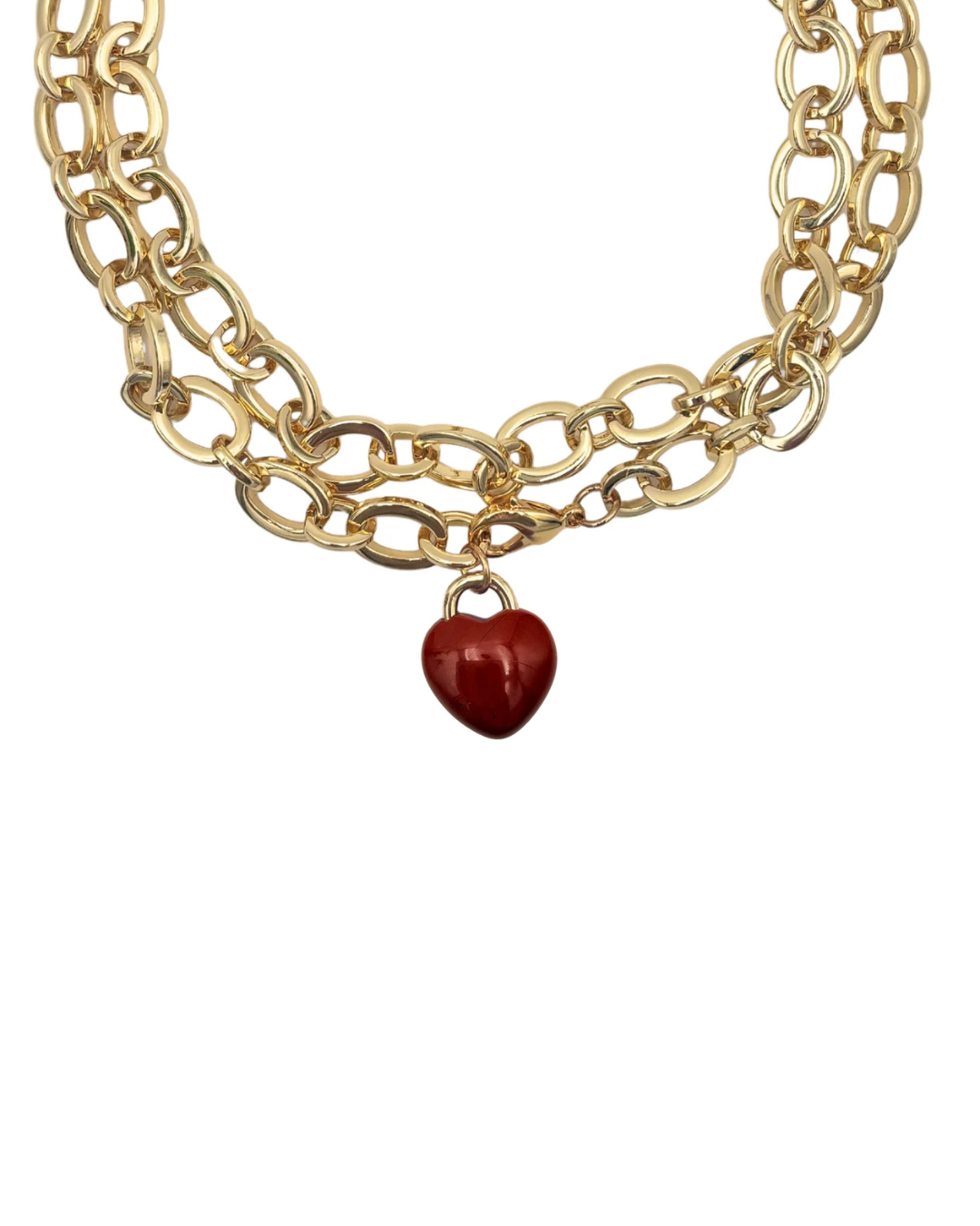 Gold chain necklace with a red heart charm on a white background