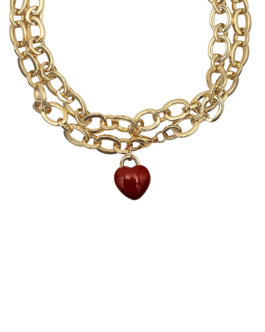 Gold chain necklace with a red heart charm on a white background