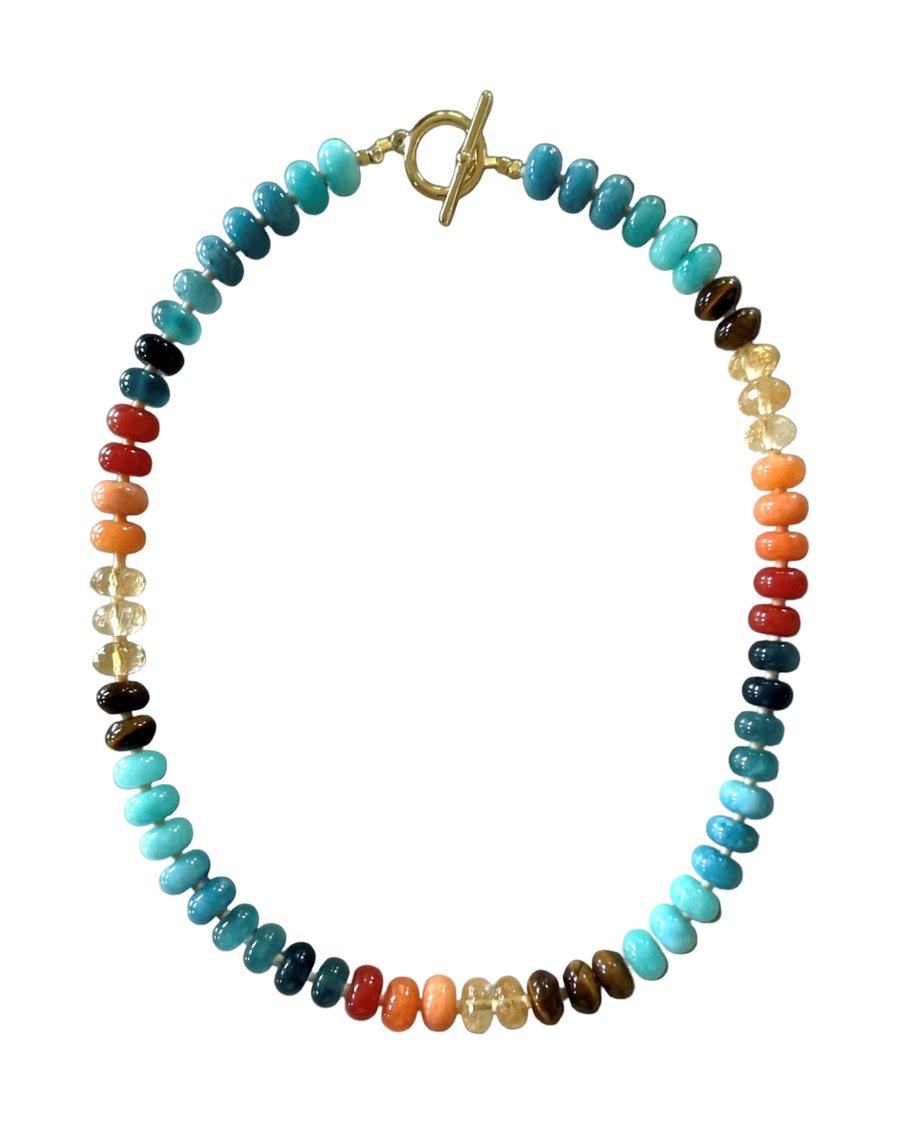 A beaded chakra necklace with a gold toggle clasp, featuring multiple colored beads representing the chakras, displayed on a clean white background.