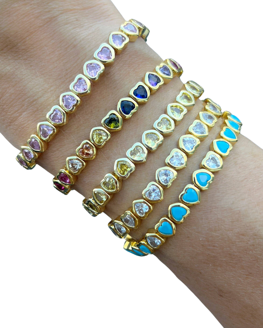Three colorful gemstone bracelets on a wrist against a white background