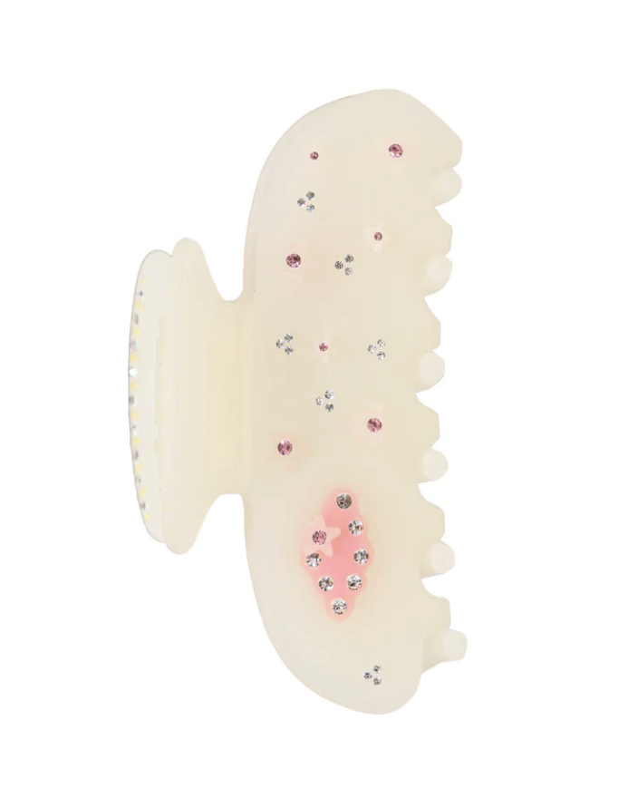 Cream-colored hair clip with decorative elements on a white background