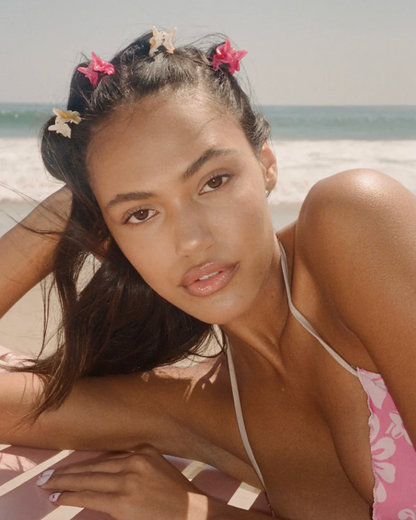 Woman in a pink bikini with floral hair accessories on a beach
