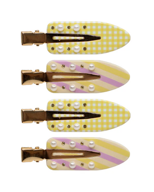 Set of four yellow and white checkered hair clips with pearl-like embellishments on a white background