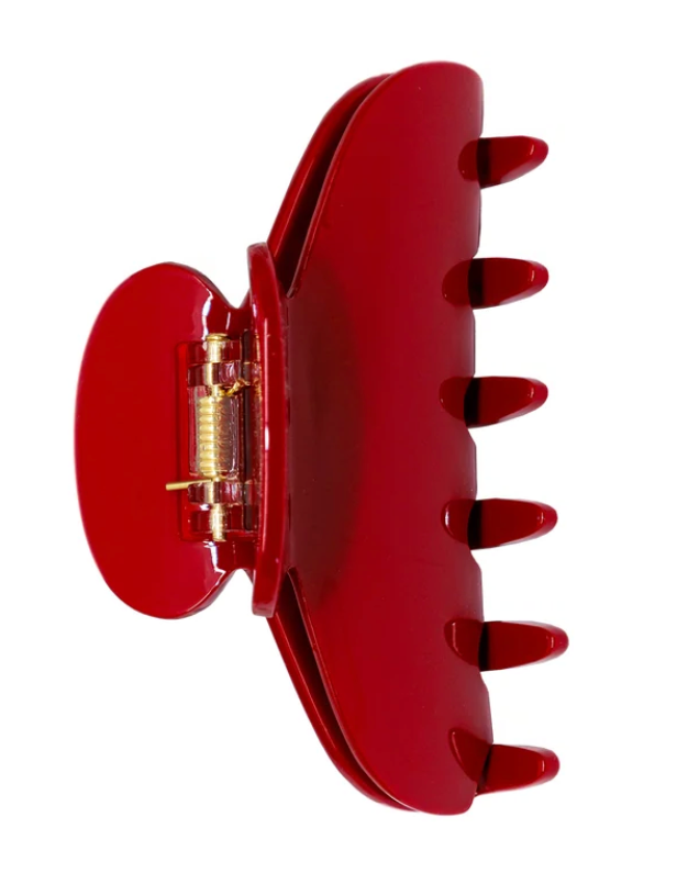 A glossy red hair claw clip with a small gold metal spring mechanism, shown against a plain white background.