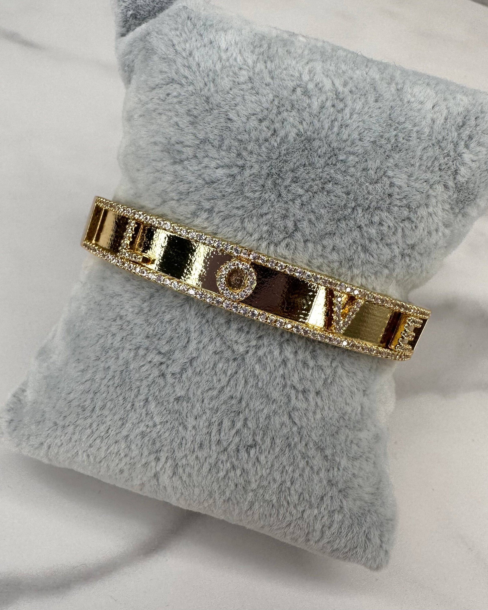 Gold bracelet on a gray pillow