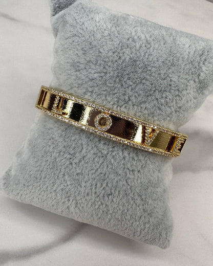 Gold bracelet on a gray pillow