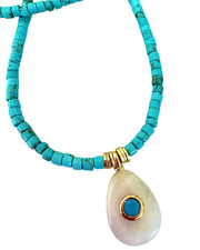 Turquoise beaded necklace with a teardrop-shaped pendant on a white background