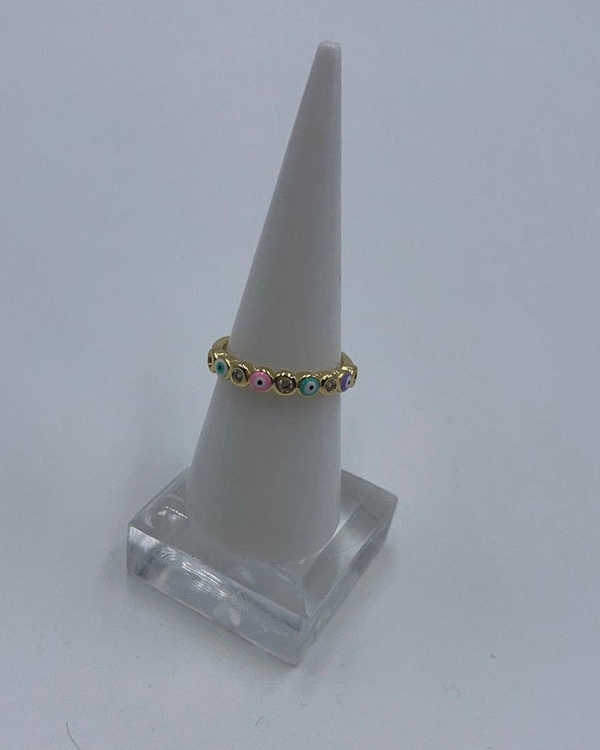 Gold ring with colorful stones on a white cone-shaped stand against a light gray background