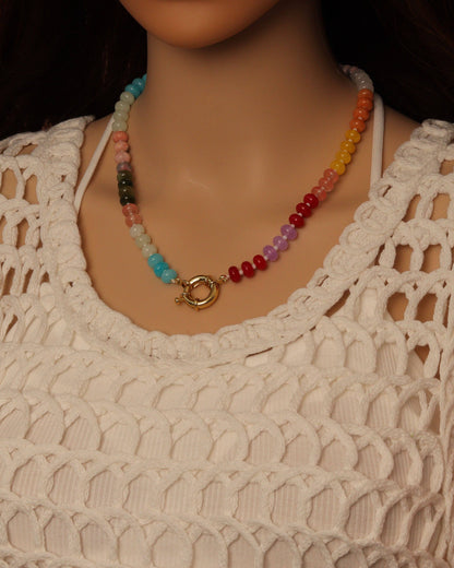 Colorful beaded necklace on a mannequin wearing a beige crochet top.