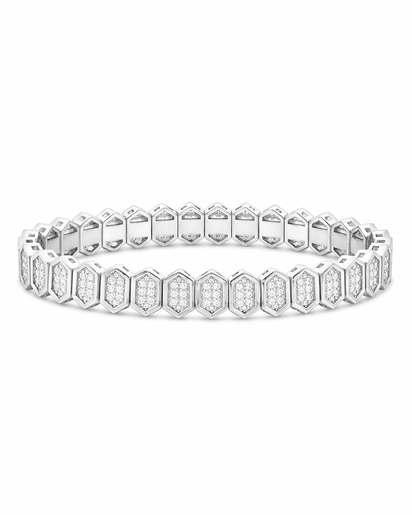 A silver-toned tennis bracelet featuring repeating hexagonal links paved with small clear stones, shown against a plain white background.