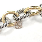 Close-up of a bracelet with interlocking gold and silver rings on a white background