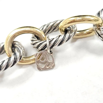 Close-up of a bracelet with interlocking gold and silver rings on a white background